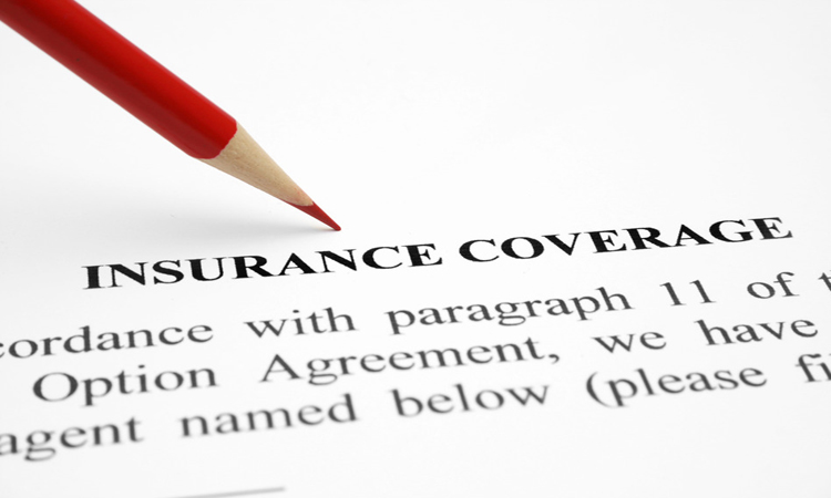 Paper contract with red pencil pointing to the words, "Insurance Coverage"