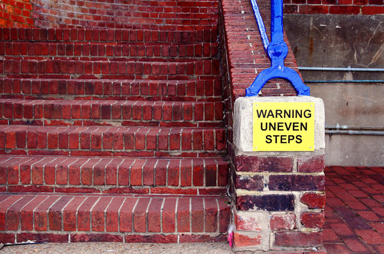 Brick staircase with a sign that reads, "Warning uneven steps"