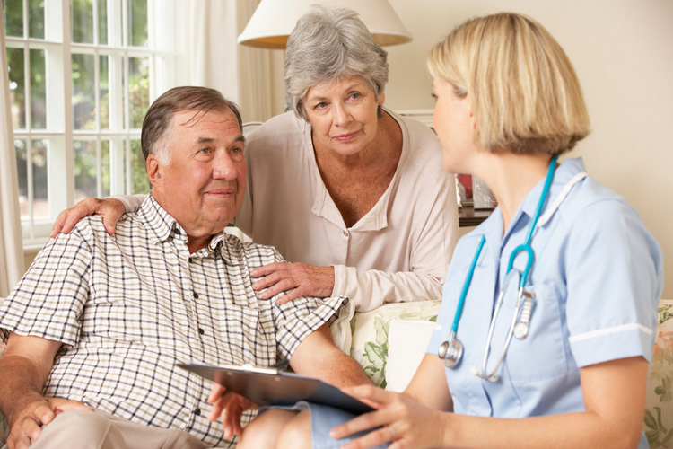 Caregiver speaking with elderly couple
