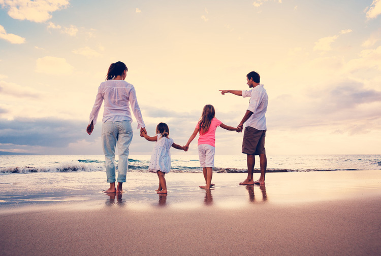 Family of four walking on beach
