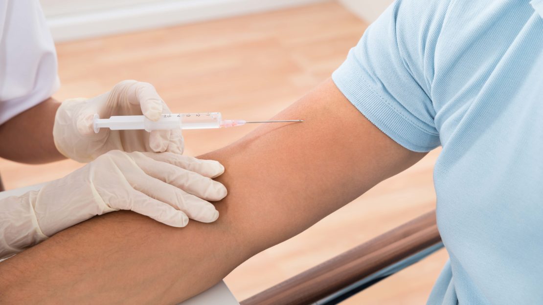 patient fighting the flu with doctor injecting flu shot into arm