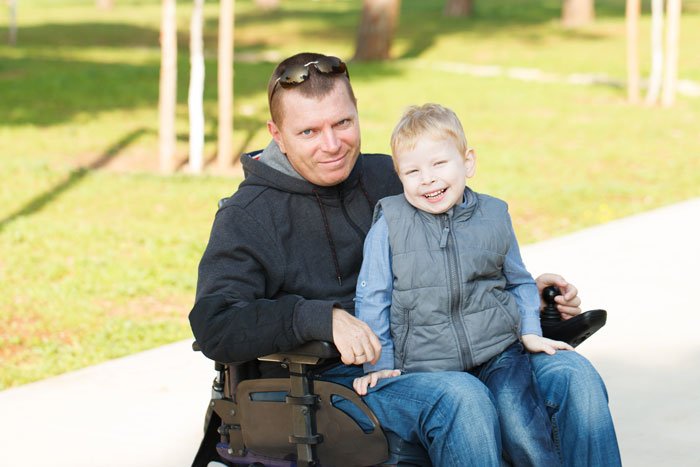man with long-term disability insurance and his son at a park