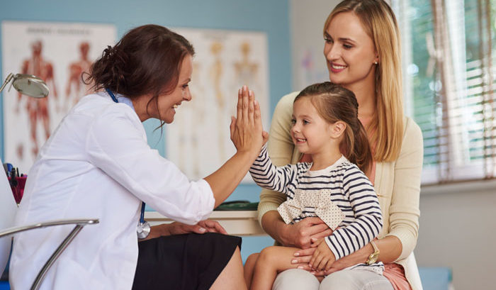 young happy doctor high fiving little girl after open enrollment