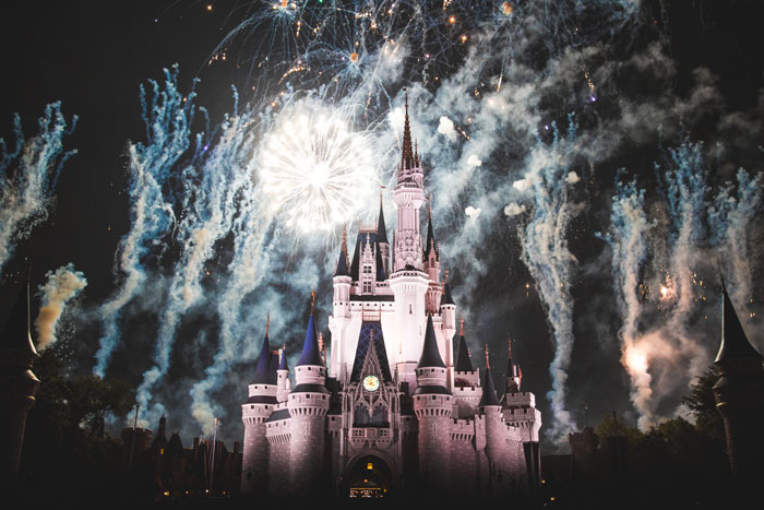 Disney magic kingdom in Orlando castle lit up with light and fireworks a top family travel destination