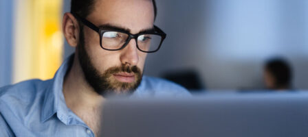 Man With Glasses Using A Computer