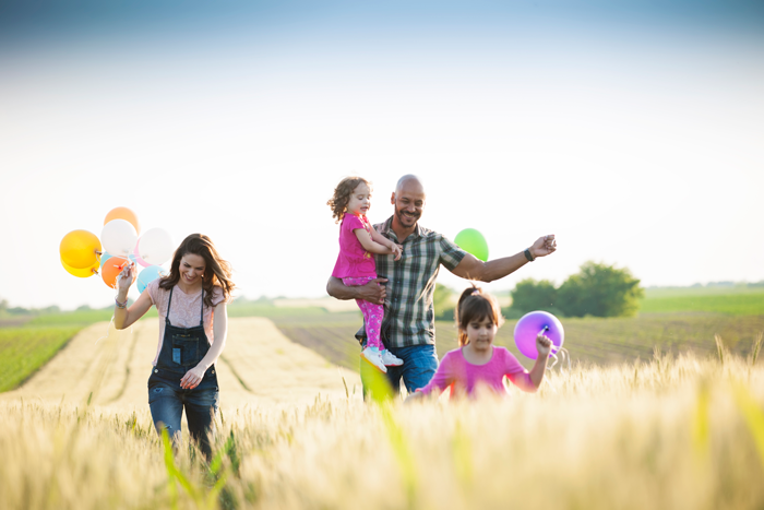 Happy family playing in a field with balloons