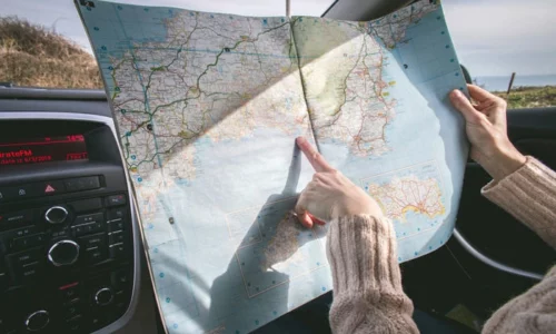 Woman In Car Pointing To Destination On Map