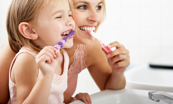 mother and child practicing good dental hygiene in bathroom