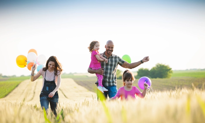 Happy family playing in a field with balloons