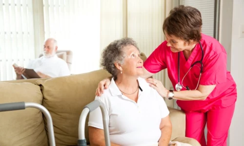 Caregiver Consoling Elderly Woman In Nursing Home