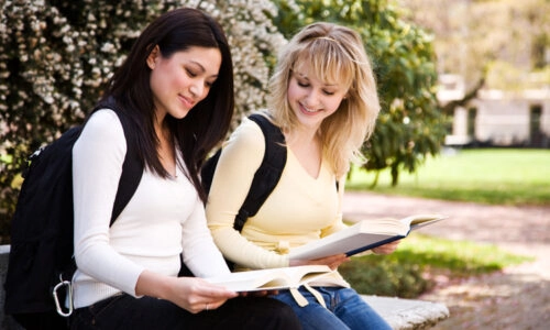 Two Female College Students Studying Outside On Campus